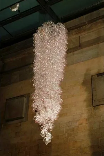 Here Come the Girls 2009
Manchester Art Gallery Atrium
1100 Wine Glasses
Lipstick
Commissioned by Manchester Art Gallery to celebrate the festive season and specifically to link to their exhibition Angels of Anarchy: Women Artists and Surrealism. The primary reference is to Meret Oppenheim's iconic fur teacup, saucer and spoon, Object. In a contemporary culture where women are just as likely to drink wine as tea the vessel still functions as a metaphor for the female body, but in the 21st century sexual politics have evolved.
Each glass is individually rimmed with lipstick using the artist's lips. Cosmetics, particularly lipstick, are often advertised as a way to enhance feminine power and choice, and one cosmetic company even used the slogan 'It's not makeup, it's ammunition'.
<em>"While thinking of 'strong women' femininity, power and Christmastime, I was reminded of the recent Boots TV commercials with crowds of women getting glammed up and marching out to celebrate to the Sugababes 'Here come the Girls'."</em> Susie MacMurray
The work offers a space for rumination on the evolution of feminism and perceptions of female power/empowerment in it's various guises – cultural/political/sexual. Also on the different ways women choose to exercise that empowerment (including binge drinking), the ambiguities it throws up, and psychological bargains we strike with ourselves.